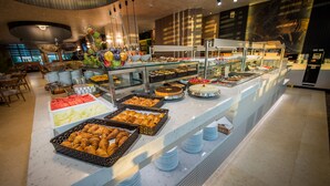 Un buffet proposant une variété de plats et un espace avec des tables et des chaises.