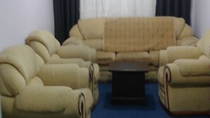 Una sala de estar con un sofá modular, una mesa de centro y piso alfombrado.