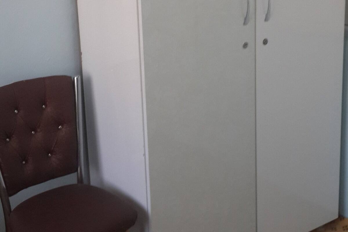 A wardrobe with two doors and a chair.