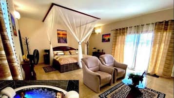 Un dormitorio con una cama con dosel, una zona de estar con dos sillones, un ventanal con cortinas y un jacuzzi en una esquina.