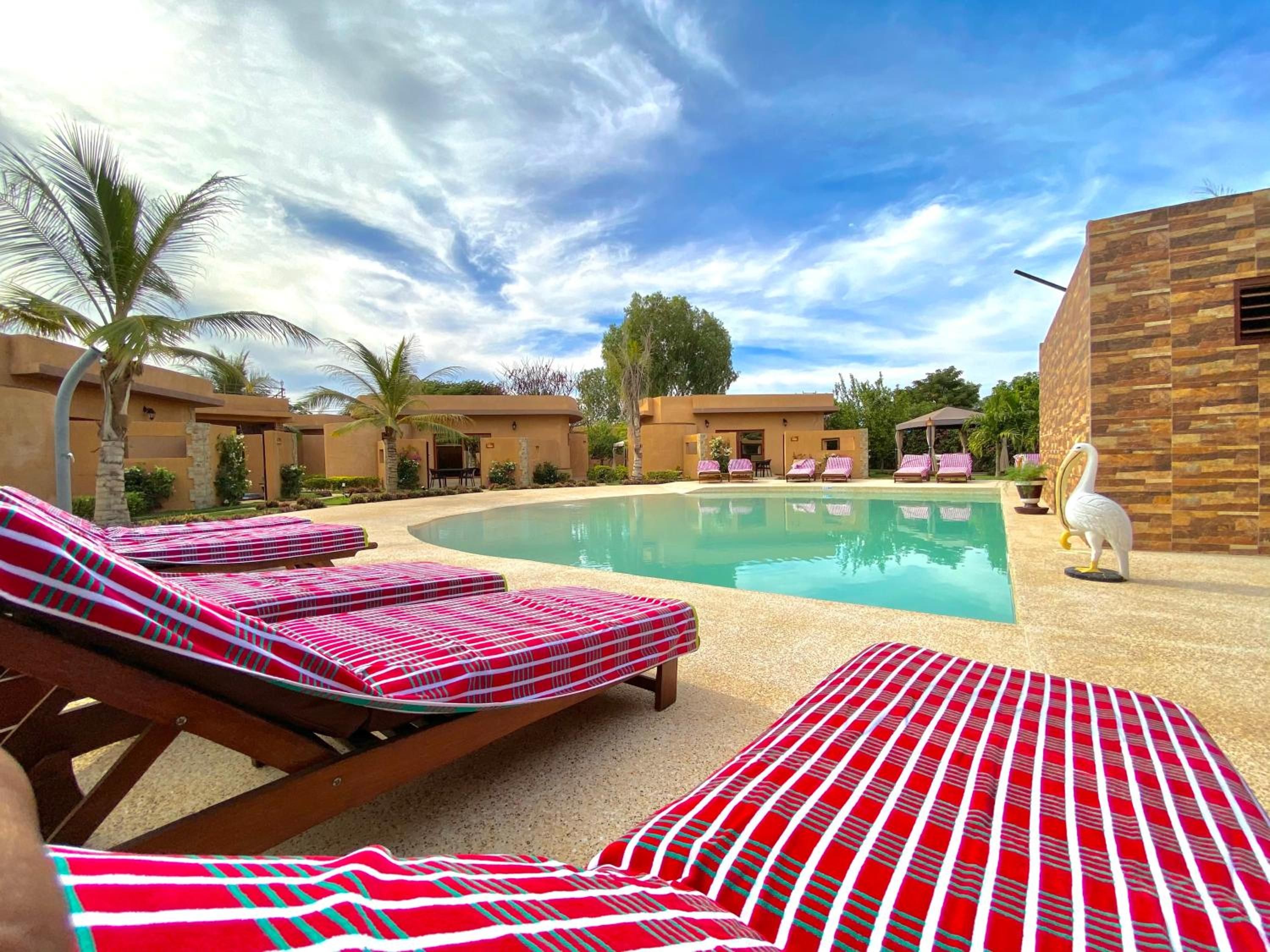 A poolside area with lounge chairs and a decorative bird statue.