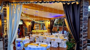 A banquet hall with round tables, white tablecloths, and yellow sashes. - Hôtel La Belle Etoile & SPA (Mbour)