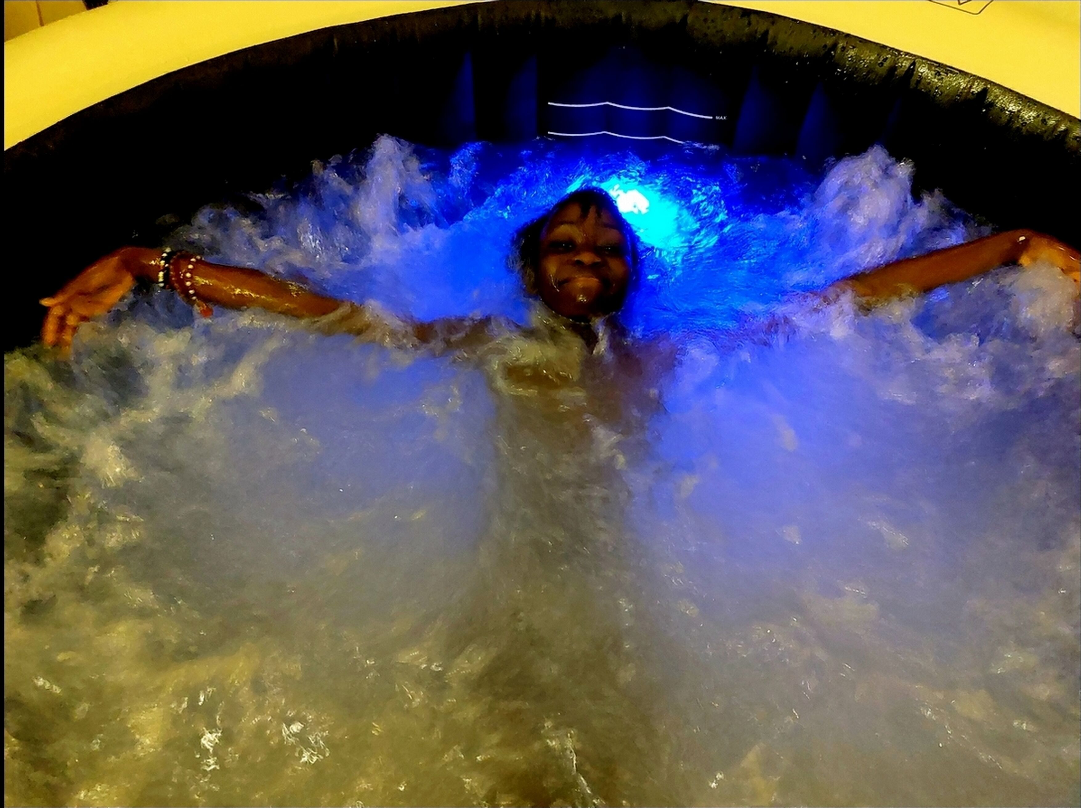 Una persona en un jacuzzi iluminado con luz azul.