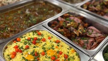 Un bufé con una variedad de platos, incluyendo arroz, carne y verduras.