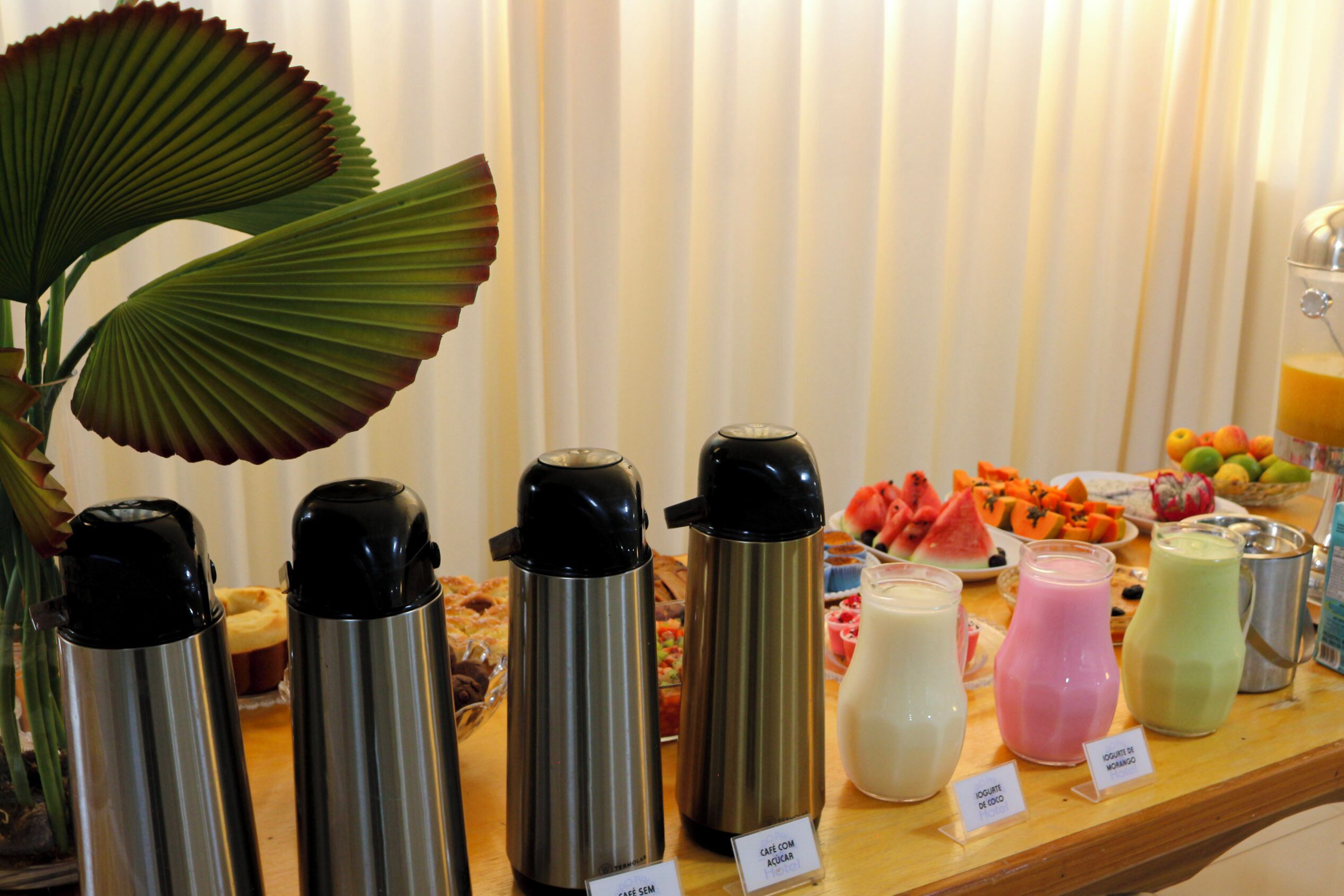 A buffet with various food items and labeled beverages.