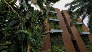 Ein modernes Gebäude mit vertikalen Holzpaneelen und einer grünen Wand mit Vegetation.