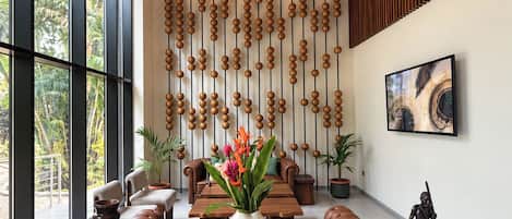 A modern interior with a wooden dining table, a hanging light fixture, and a wall with vertical wooden slats.