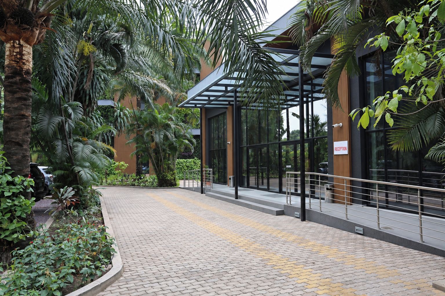 A reception area with a paved entrance, a glass door, and a sign indicating the reception.