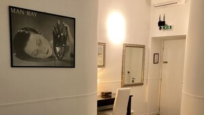 Ein Hotelzimmer mit einem Bett, einem Schreibtisch, einem Sessel, einem Spiegel und einem gerahmten Bild an der Wand.