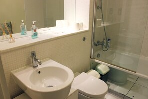 A bathroom with a sink, toilet, and glass-enclosed shower.