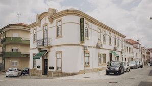 A historic building with a curved facade, multiple balconies, and a green awning. - Hotel Império do Rei (Castelo Branco)