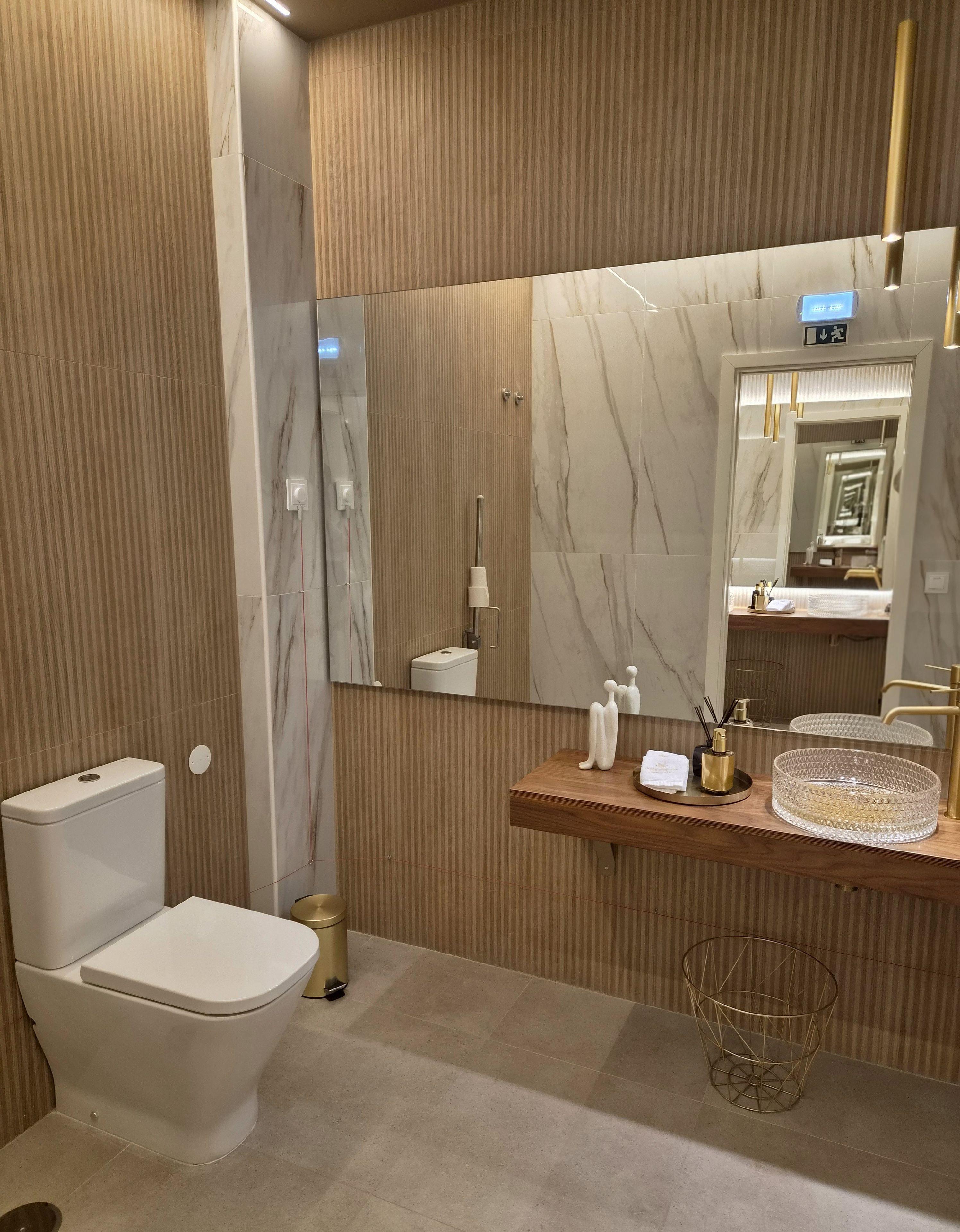 A modern bathroom with a toilet, sink, and mirror.