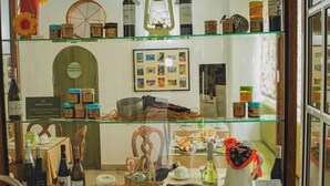 A display case with various bottles and jars, a framed collage, and some decorative items. - Hotel Império do Rei (Castelo Branco)