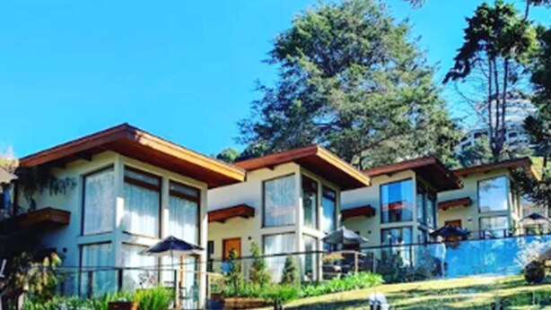 A hotel with a pool, multiple buildings, and a clear blue sky. - Hotel Boutique Quebra-Noz Conforto e Natureza (Campos do Jordão)