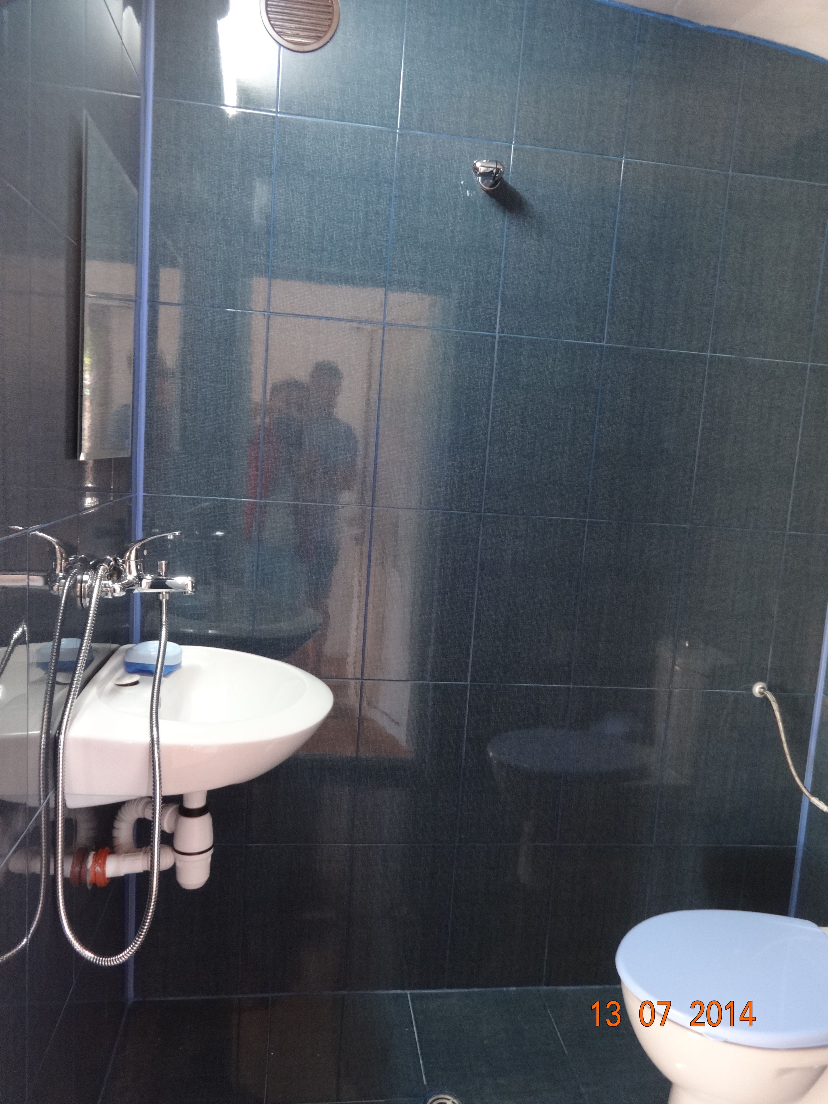 Un baño con lavamanos blanco, inodoro y zona de ducha.