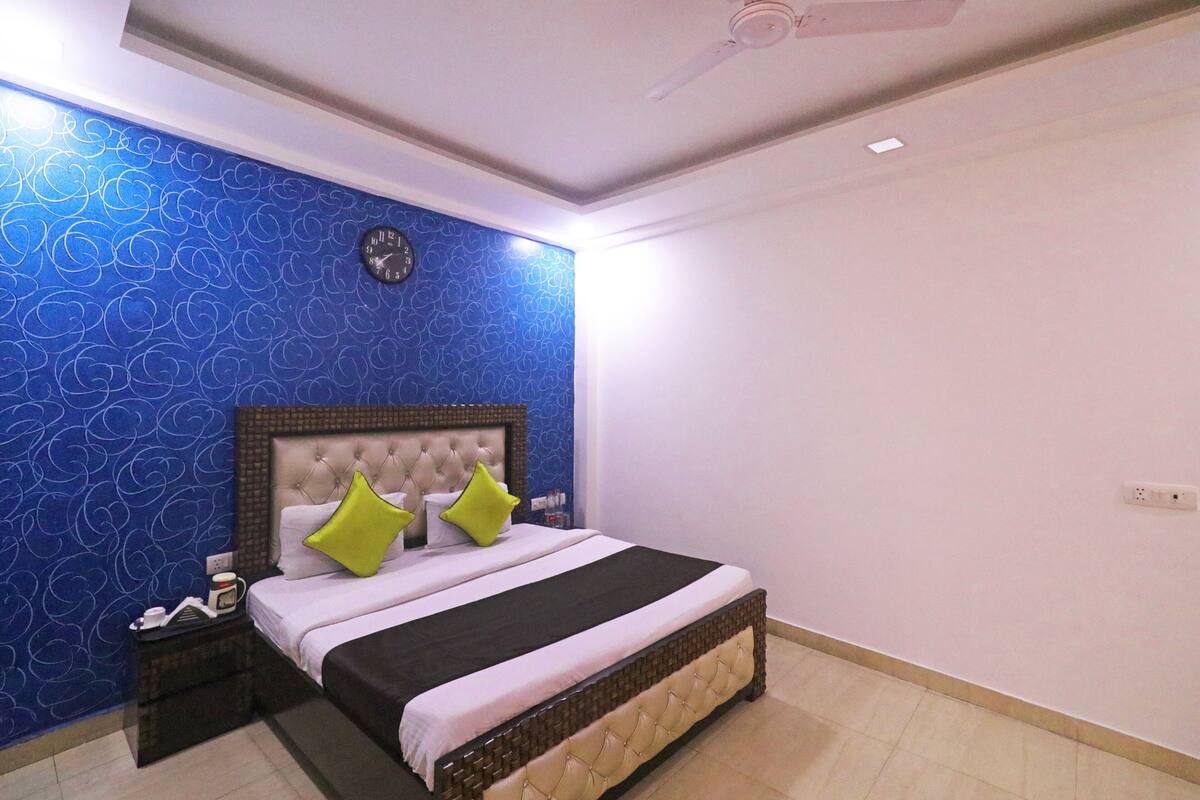 Ein Schlafzimmer mit einem Bett, einem Nachttisch und einer Wanduhr.
