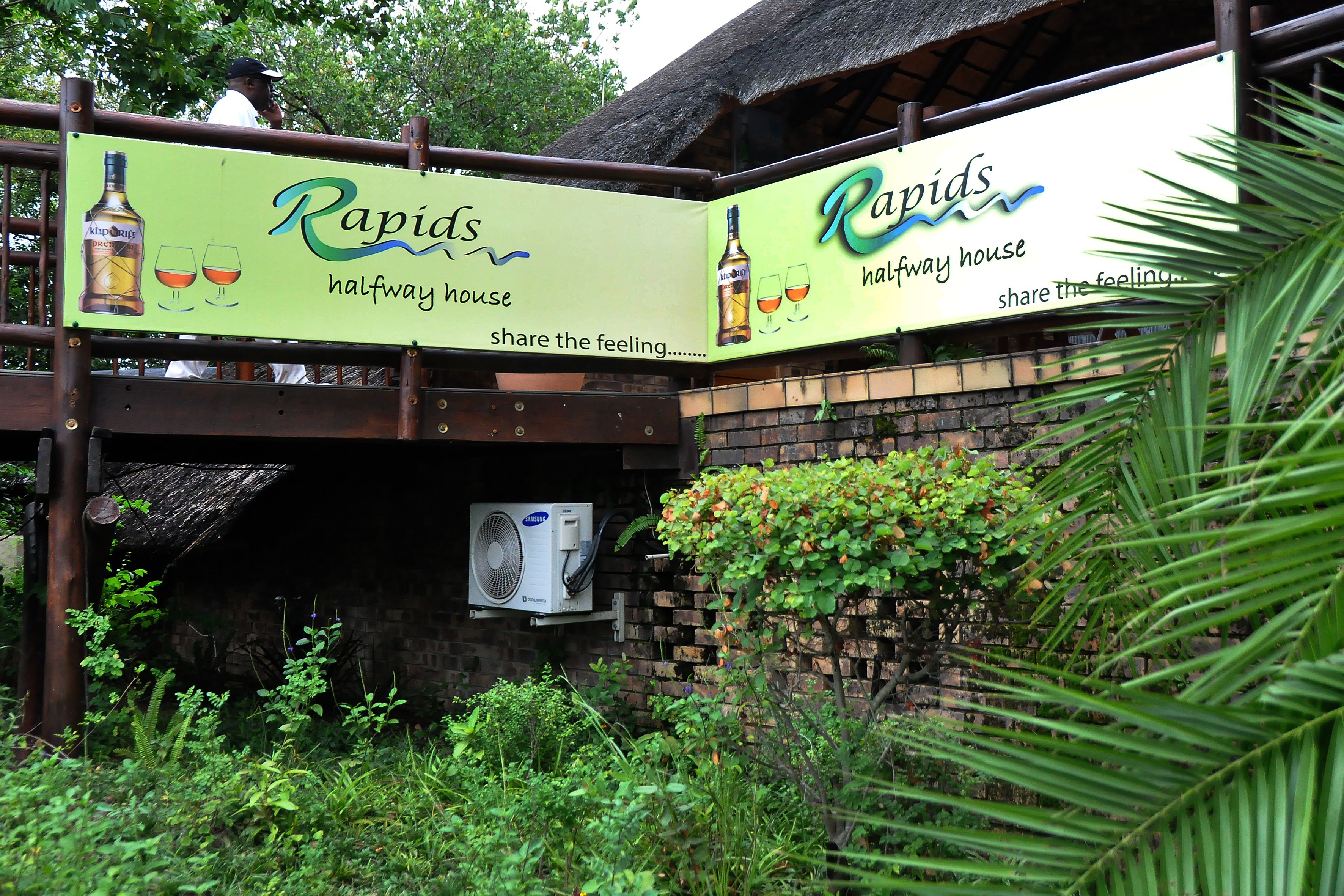 Un panneau indiquant « Rapids Halfway House », avec un logo et du texte.