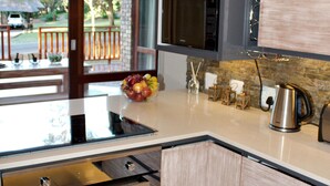 A modern kitchen with a built-in oven, microwave, and stainless steel kettle.
