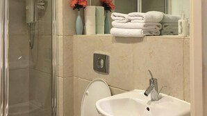A modern bathroom with a glass-enclosed shower, a white sink, and a toilet. - The Greengate Apartment (Salford)
