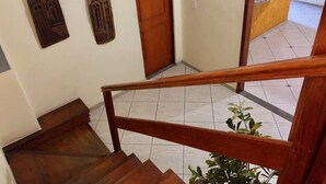 Una escalera con barandillas de madera y una puerta de madera con un letrero encima.