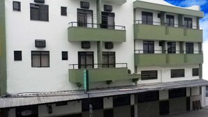 Un hotel de varios pisos con balcones, techo plano y un letrero que indica que es un hotel.