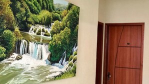 Un cuadro colgado en la pared que muestra una cascada rodeada de abundante vegetación.