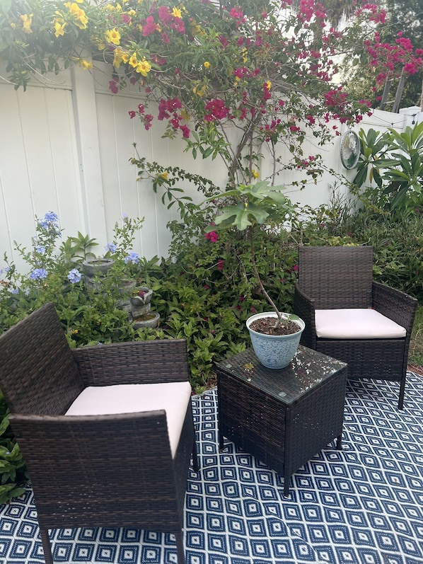 Ein Patio mit Rattanmöbeln und einem gemusterten Boden.