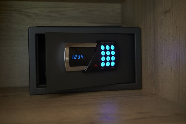 A digital safe with a keypad and a display showing the time 12:34. - Appartements Gappmaier (Saalbach-Hinterglemm)