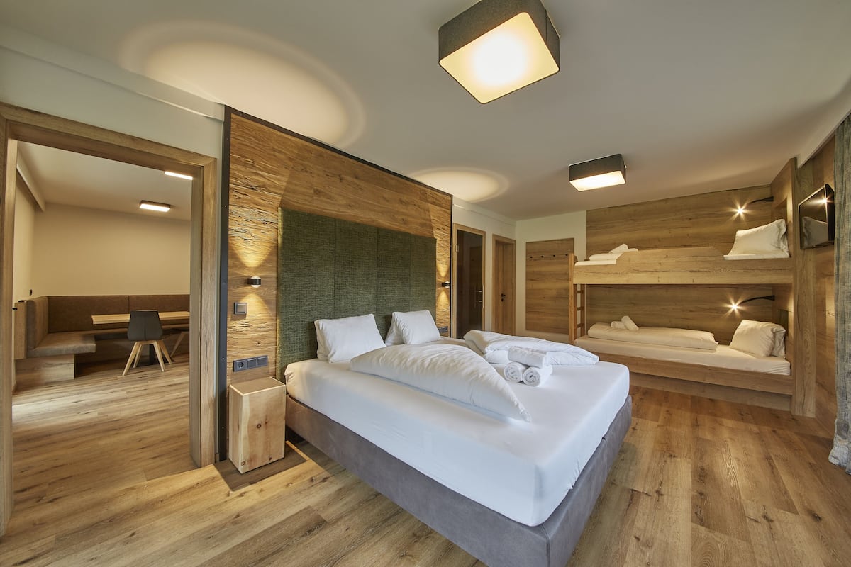 Un dormitorio moderno con una cama grande, paredes de madera y un banco empotrado.
