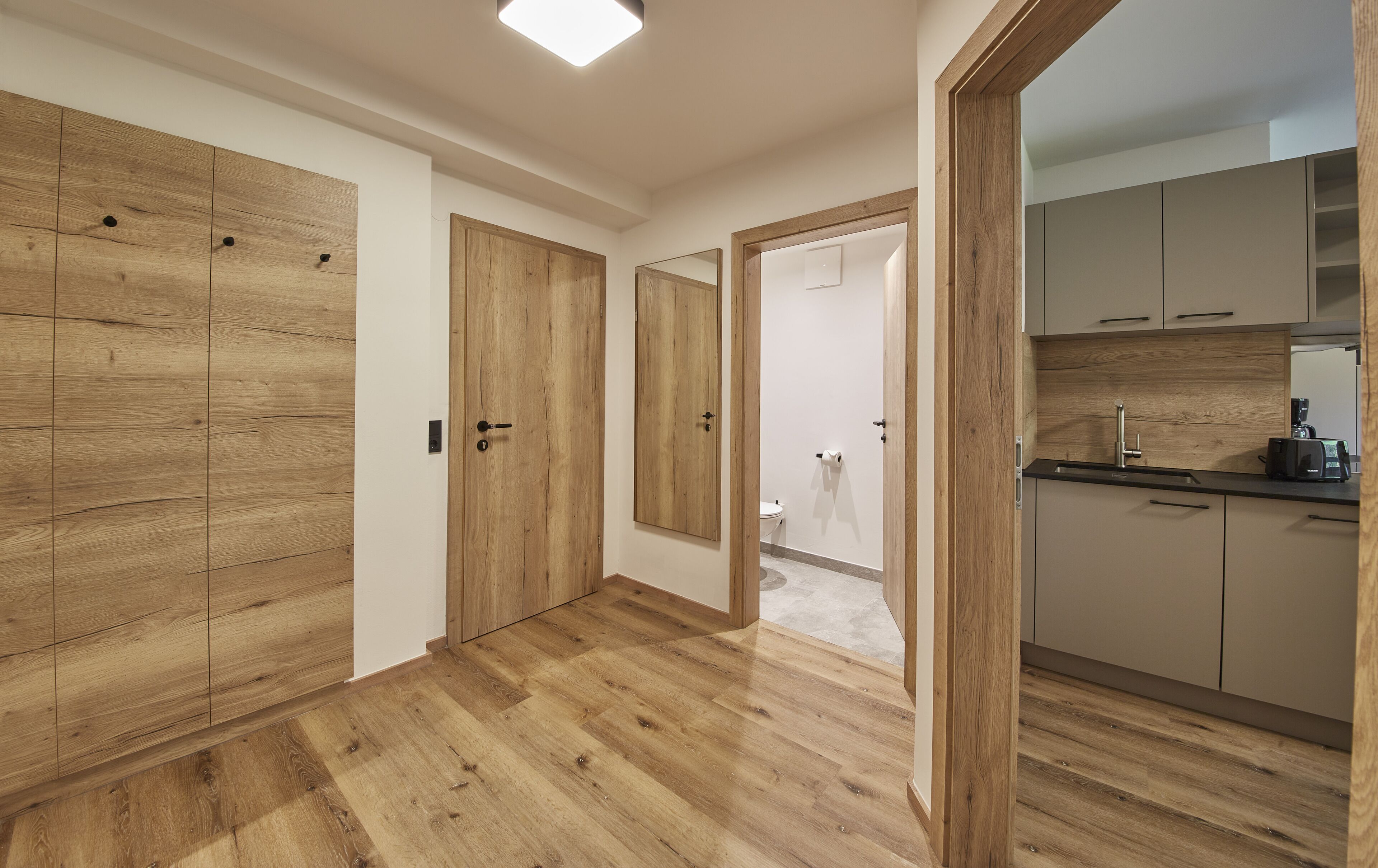 A modern kitchen with wooden cabinets and a built-in oven.