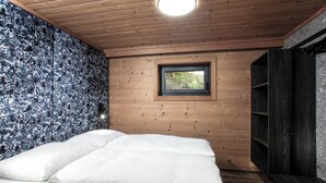 A bedroom with a bed, a window, and a wardrobe. - FIVE SEASONS | Hideaway Saalbach (Saalbach-Hinterglemm)