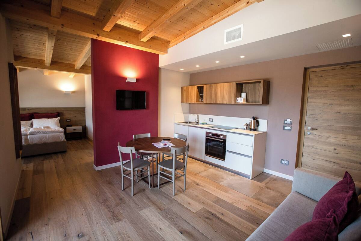 A compact living space with a dining area, kitchenette, and a bedroom.