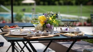 An outdoor dining setup with a table set for a meal, including bowls, plates, and glasses. - Cobue Wine Resort & SPA (Pozzolengo)