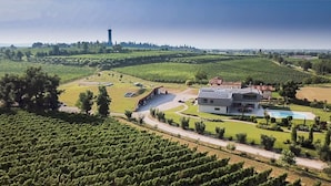 A large estate with expansive vineyard fields, a swimming pool, and a modern house with a large garage. - Cobue Wine Resort & SPA (Pozzolengo)