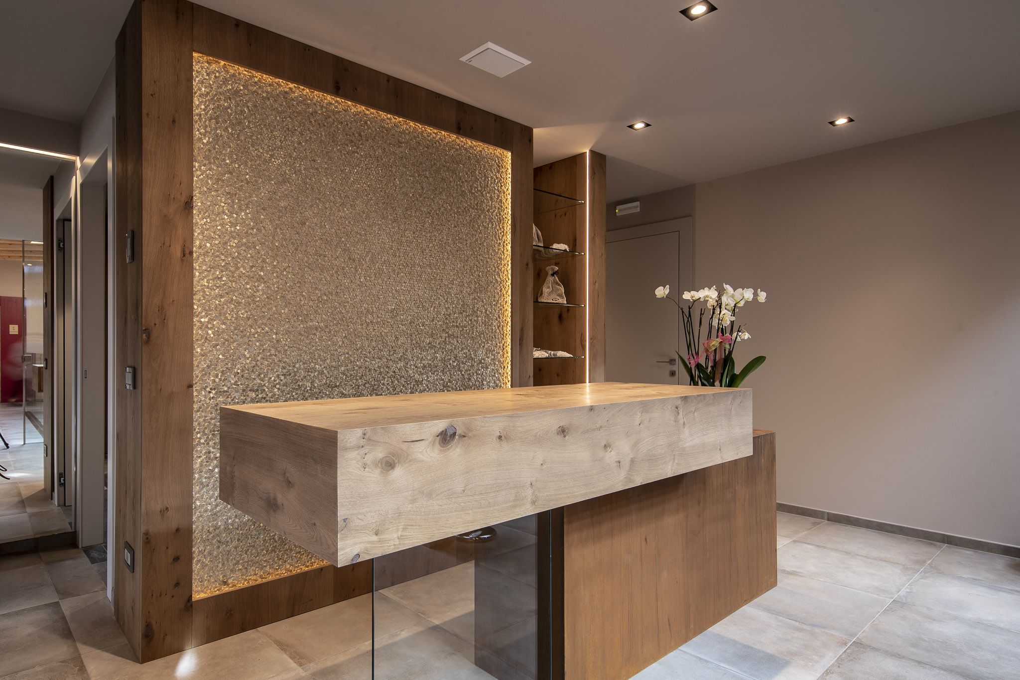 Ein Empfangsschalter mit Holzoptik und einer strukturierten Wand im Hintergrund.