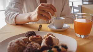 A person sitting at a table with a plate of pastries, a cup of coffee, and a glass of orange juice. - Terra Ferma Rooms & More (Salzano)