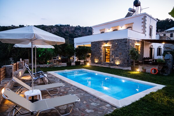 Una piscina al aire libre de temporada, sombrillas