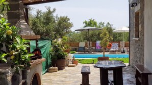 A stone patio with a pool, outdoor furniture, and potted plants. - Traditional Villa in Fres (Apokoronas)