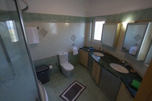 A bathroom with two sinks, a toilet, and a shower area. - Villa Roula 6BR (Chania)