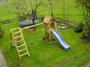 A playground with a swing set, slide, and climbing structure.