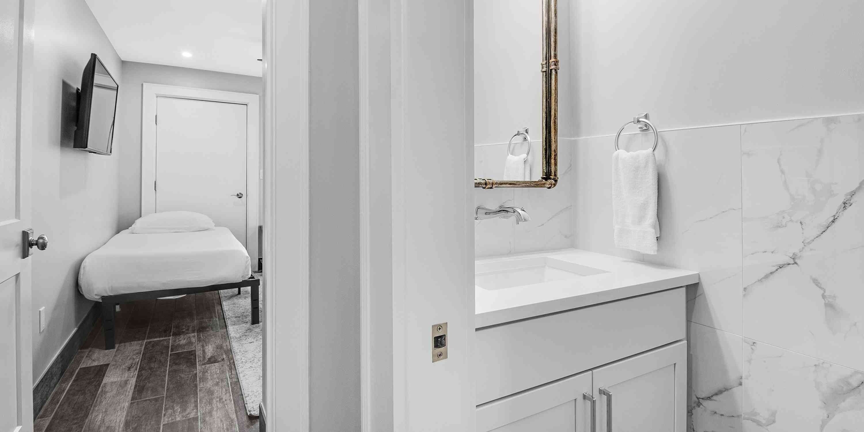 Un baño moderno con un lavamanos blanco, un espejo y un inodoro.