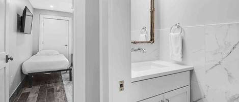 Un baño moderno con un lavamanos blanco, un espejo y un inodoro.