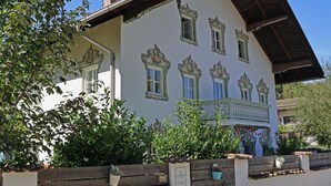 A traditional building with ornate window frames, a wooden balcony, and a chimney.