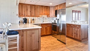 Une cuisine moderne avec des meubles en bois, des appareils en acier inoxydable et un îlot central.