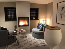 Una sala de estar con chimenea, un sofá, una mesa de centro y un jarrón grande.