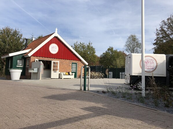 A charming local business stands alongside a quiet outdoor setting with trees and a clear sky.
