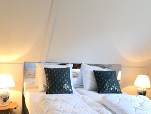 Experience comfort in this stylish room with a large bed, two bedside tables, and ambient lighting.