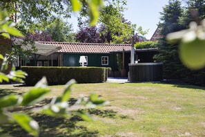 Surrounded by lush greenery, this serene building features a charming covered porch and a well-manicured lawn.