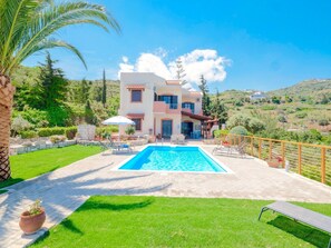 A two-story house with a swimming pool, surrounded by a well-maintained lawn and a view of hills. - Villa Lygaria (Malevizi)