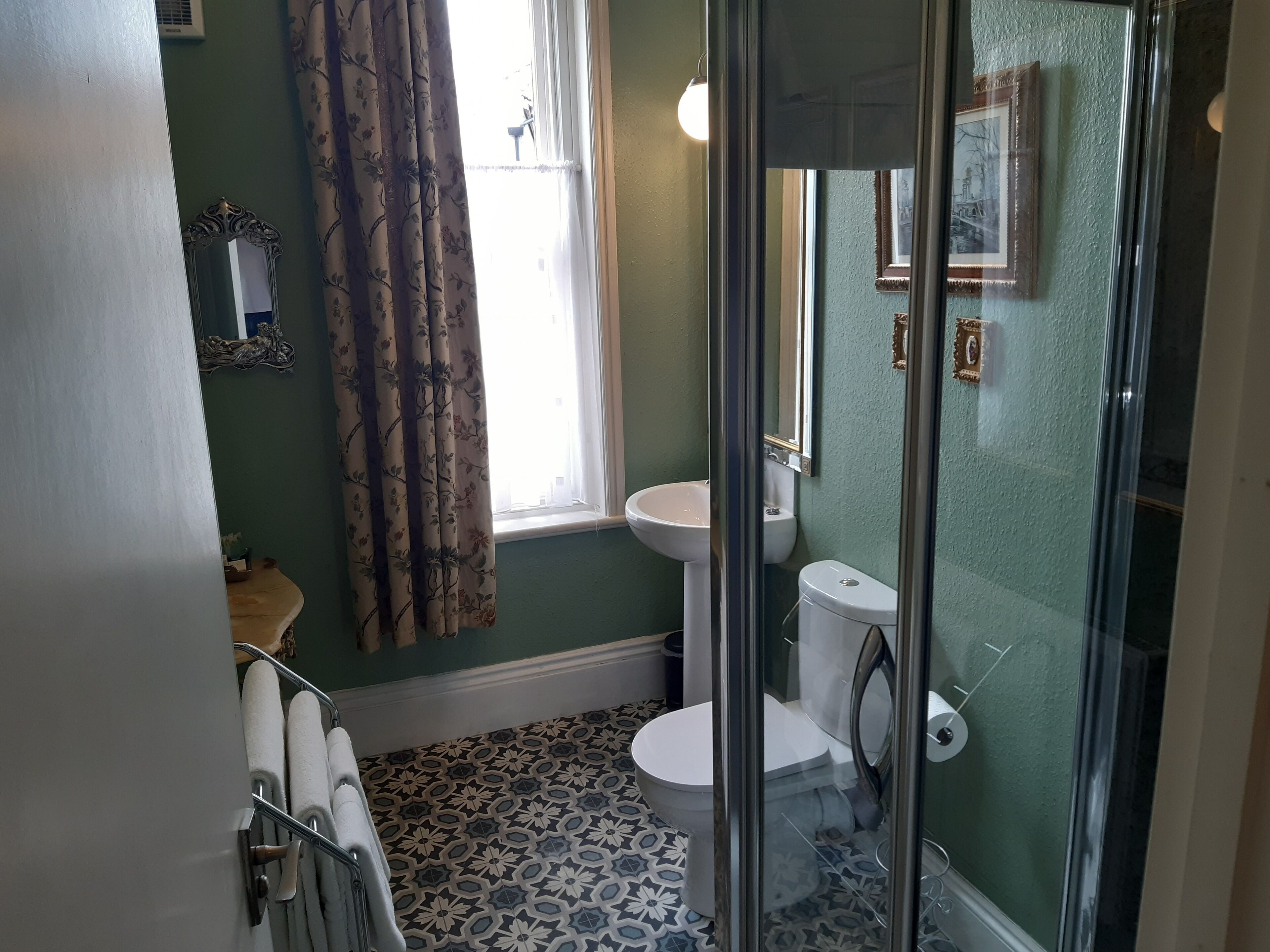 A bathroom with a toilet, sink, and shower area.